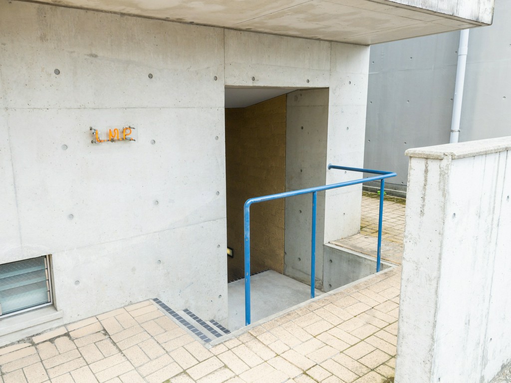 コンクリートの壁に小さなネオン管。ここが店への入口