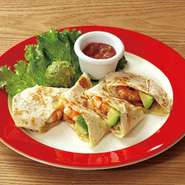 フラワートルティーヤの中にスパイシーに味付けした エビ・アボカド・サルサを入れて巻き、焼き上げました。