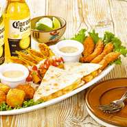 チキンフィンガー・カラマリ・タキトス・チキンケサディーヤの盛り合わせ。