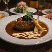 【キッチン　ハセガワ】の名物であり、料理人自身が最も多くつくり、愛してやまない一品。こだわりを重ねた自家製デミグラスソースが、ハンバーグに深いコクと奥行きのある味わいを与えています。