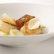 天然の帆立をカリッと焼き上げ、三浦大根のコンソメスープにこうばしい香りをプラス。大根は白い部分を大根もちにしてサクサクに揚げ、葉と皮はオイルと一緒にミキサーにかけて濾しスープに垂らして丸ごと使います。