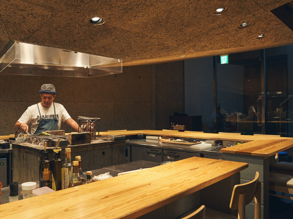 洞窟で焚き火を囲むようなイメージのインテリアで安心感を演出