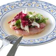 旬の魚を薄切りにして野菜にオリーブオイルと特製ソースで味付けした人気メニュー。