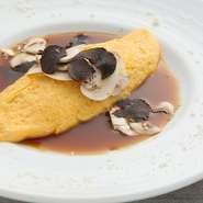 ふわふわのオムレツにトリュフとチーズを削って黒胡椒とブラウンソースをたっぷりかけるシェフ自慢の人気料理のひとつです。