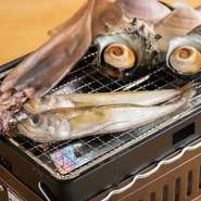 各テーブル席で焼きながら食べる「浜焼き」スタイル。魚の表面が香ばしく色づいたら、ハマグリは口を開いたら、サザエは殻の中がグツグツ煮立ってきたら食べ頃です。