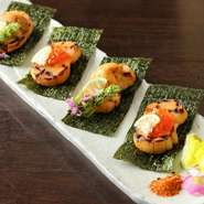 醤油焼きにした帆立をパリパリの海苔の上に乗せて、極上のウニやイクラを巻いていただきます。色彩豊かな見た目も魅力。口の中いっぱいに濃厚な旨みが広がります。