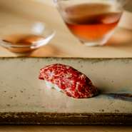 シグネチャーでもある鯨は、夏場はニタリクジラやイワシクジラ、冬場はナガスクジラなど時期によって使い分けています。写真は、ニタリクジラの尾身。日本酒『伊根満開 古代米酒』と共にどうぞ。