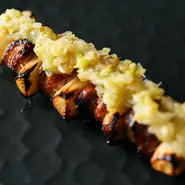 ラム肉とホワイトアスパラを交互にした串焼き。上にはフキノトウとウドを合わせたさっぱりとしたソースをのせました。合わせる野菜は新玉ネギなど、その季節ごとの食材で。2か月ごとに変わる味付けも愉しみな逸品。

