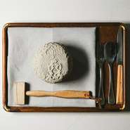 木槌で叩くとトロトロ玉ねぎの登場！玉ねぎを丸ごと土器で包み3～4時間かけて焼くことで、素材本来の甘みを引き出します。木版の模様で目にも楽しい仕上がり。古代に思いを馳せ現代的に表現した心くすぐる逸品です。